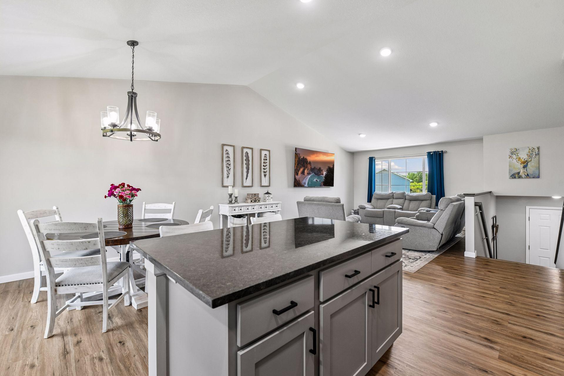 View from kitchen towards main level living room, entry and sliding door to the right of dining area.