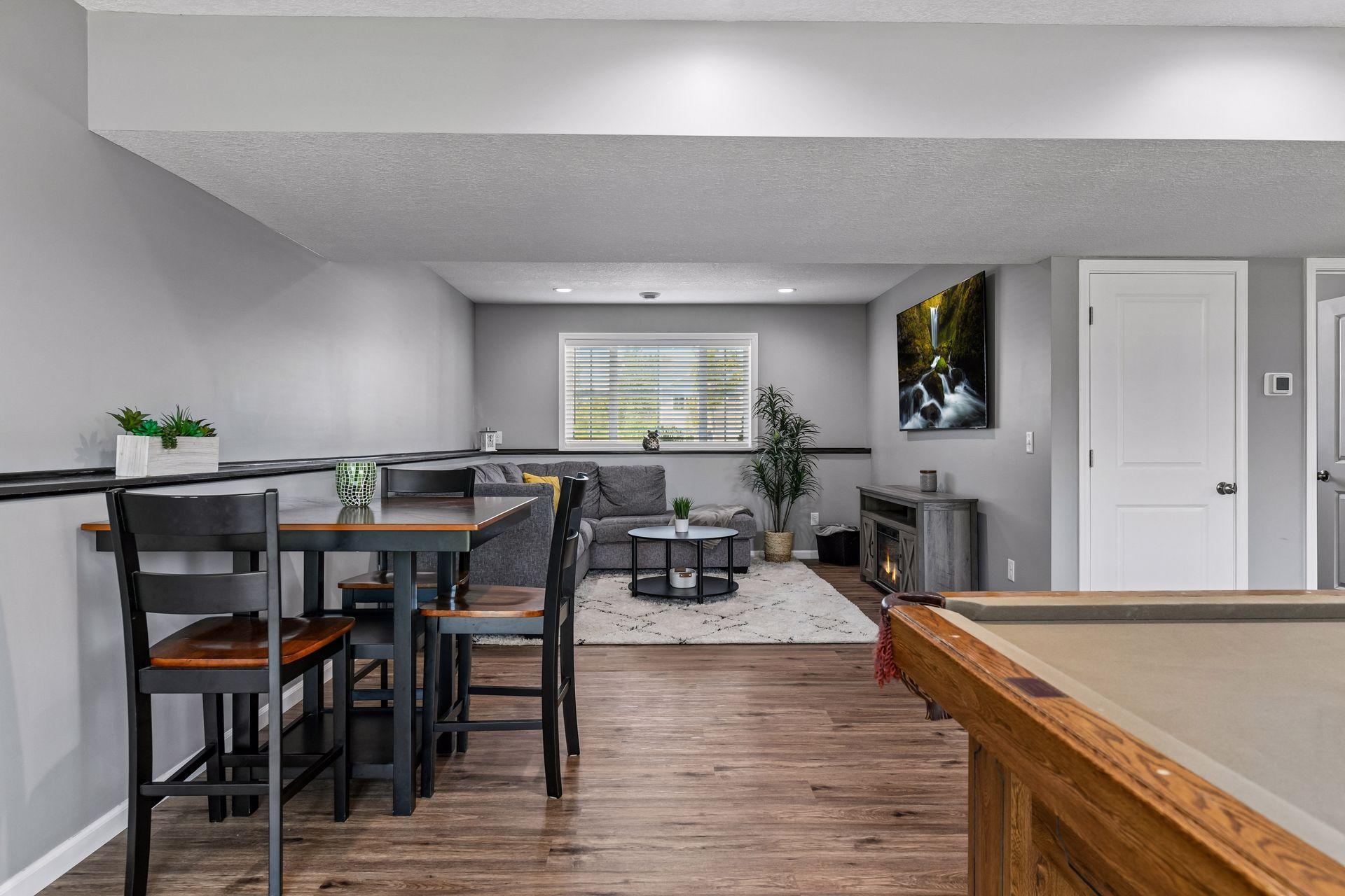 Lower-level family room with highboy game table to play cards or games while others enjoy the pool table.