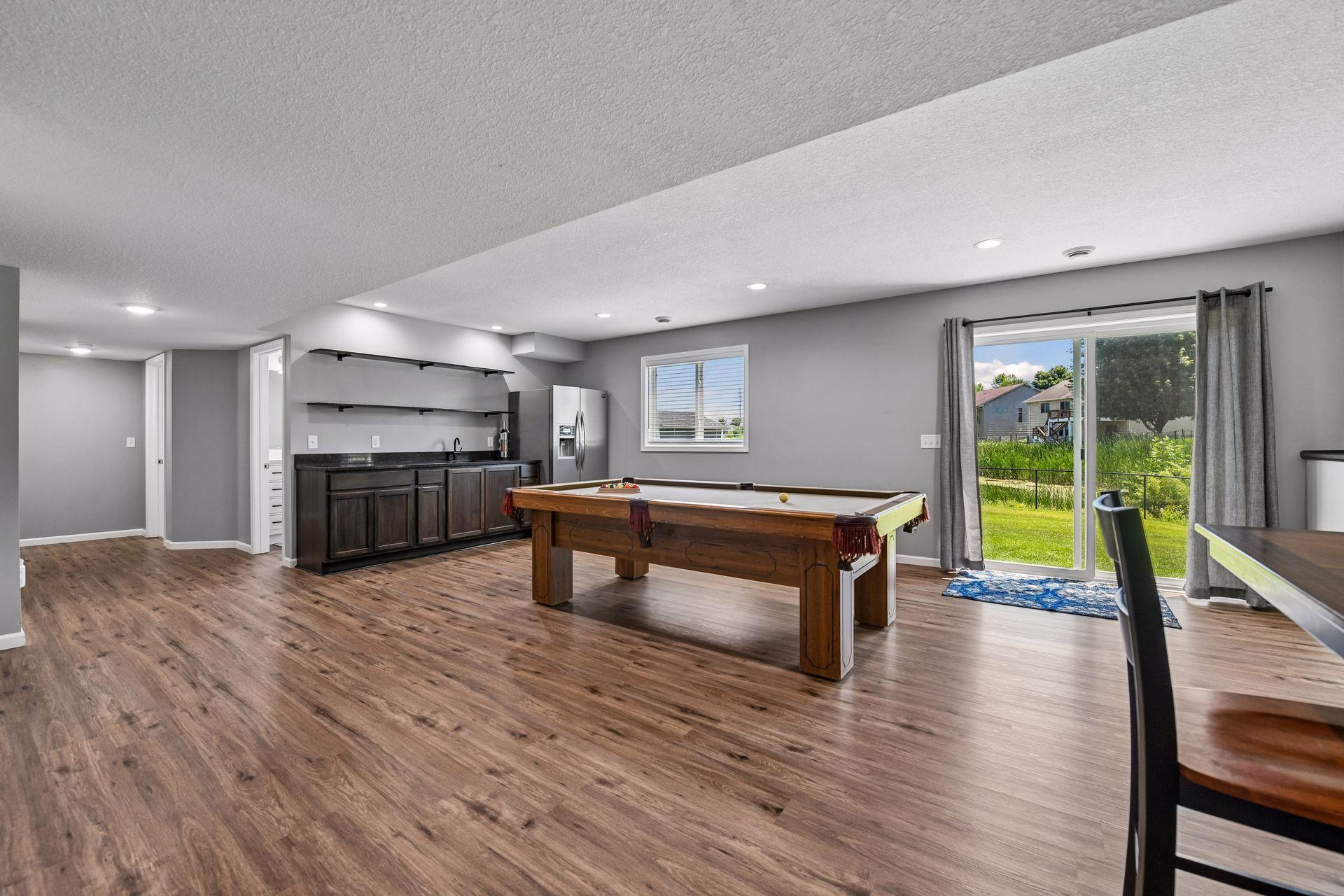Seller just finished wet bar wall with additional refrigerator, custom cabinetry, granite countertop and shelving.
