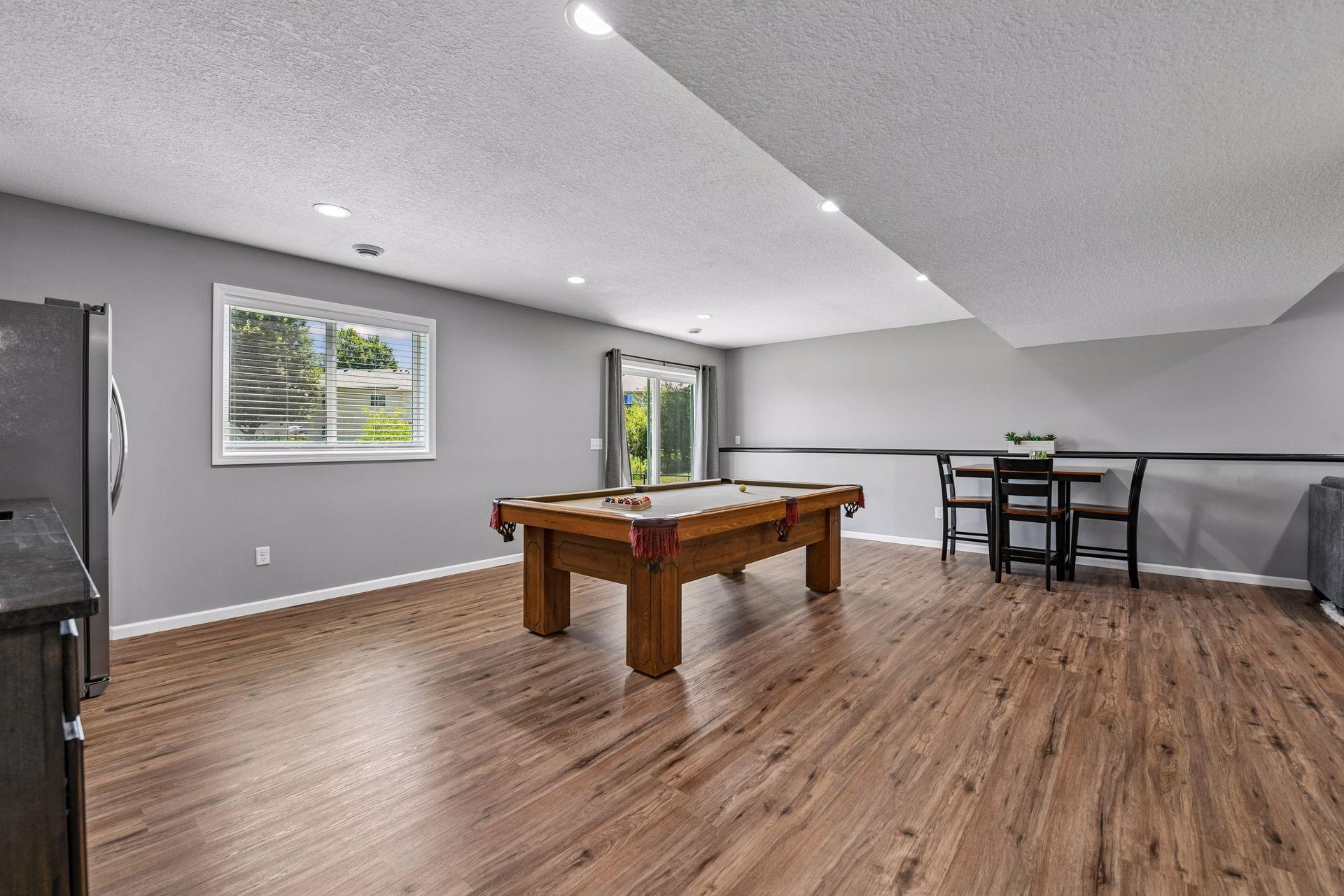 Billard game area showing walkout to flat backyard. Newly added wet bar wall to the left in photo.