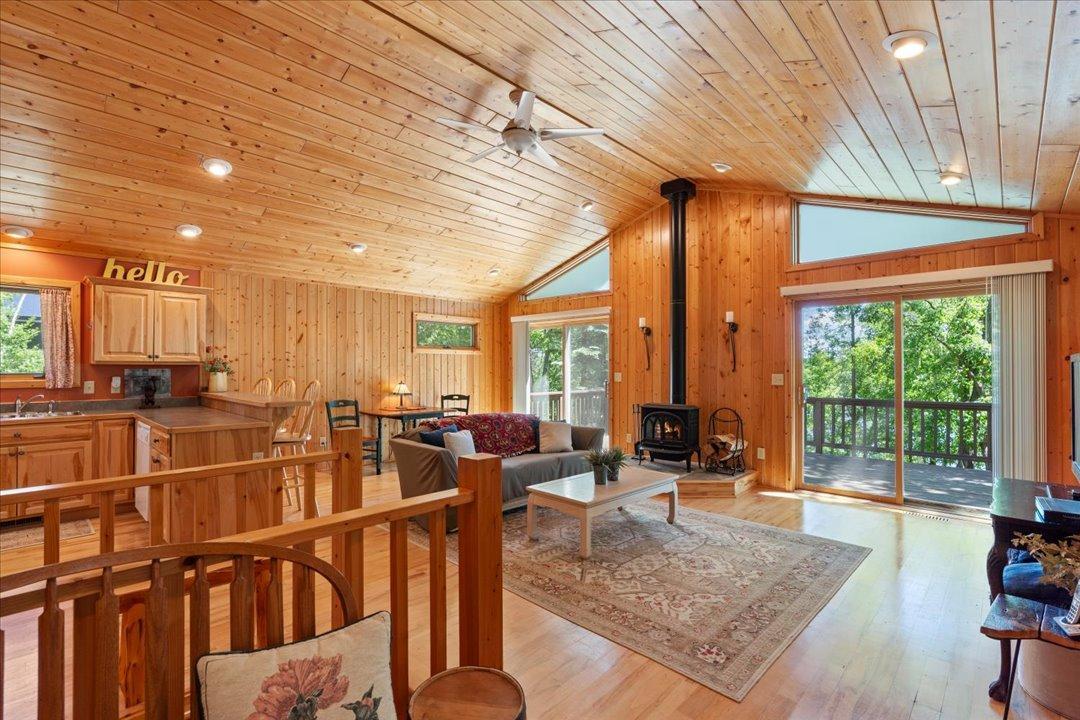 Step into the inviting living room, where vaulted ceilings, an open-concept design, and warm natural wood finishes capture the timeless charm of a classic Up North cabin