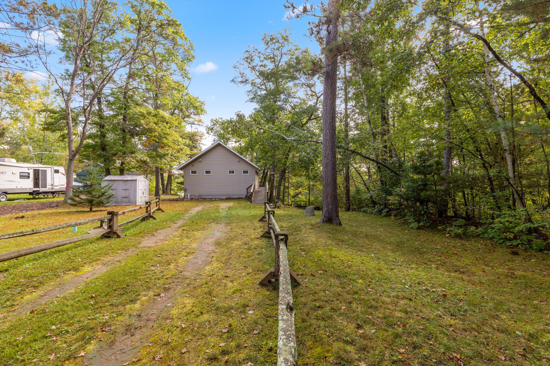 The open driveway offers plenty of parking with a convenient storage shed for added functionality
