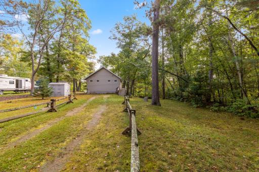 The open driveway offers plenty of parking with a convenient storage shed for added functionality