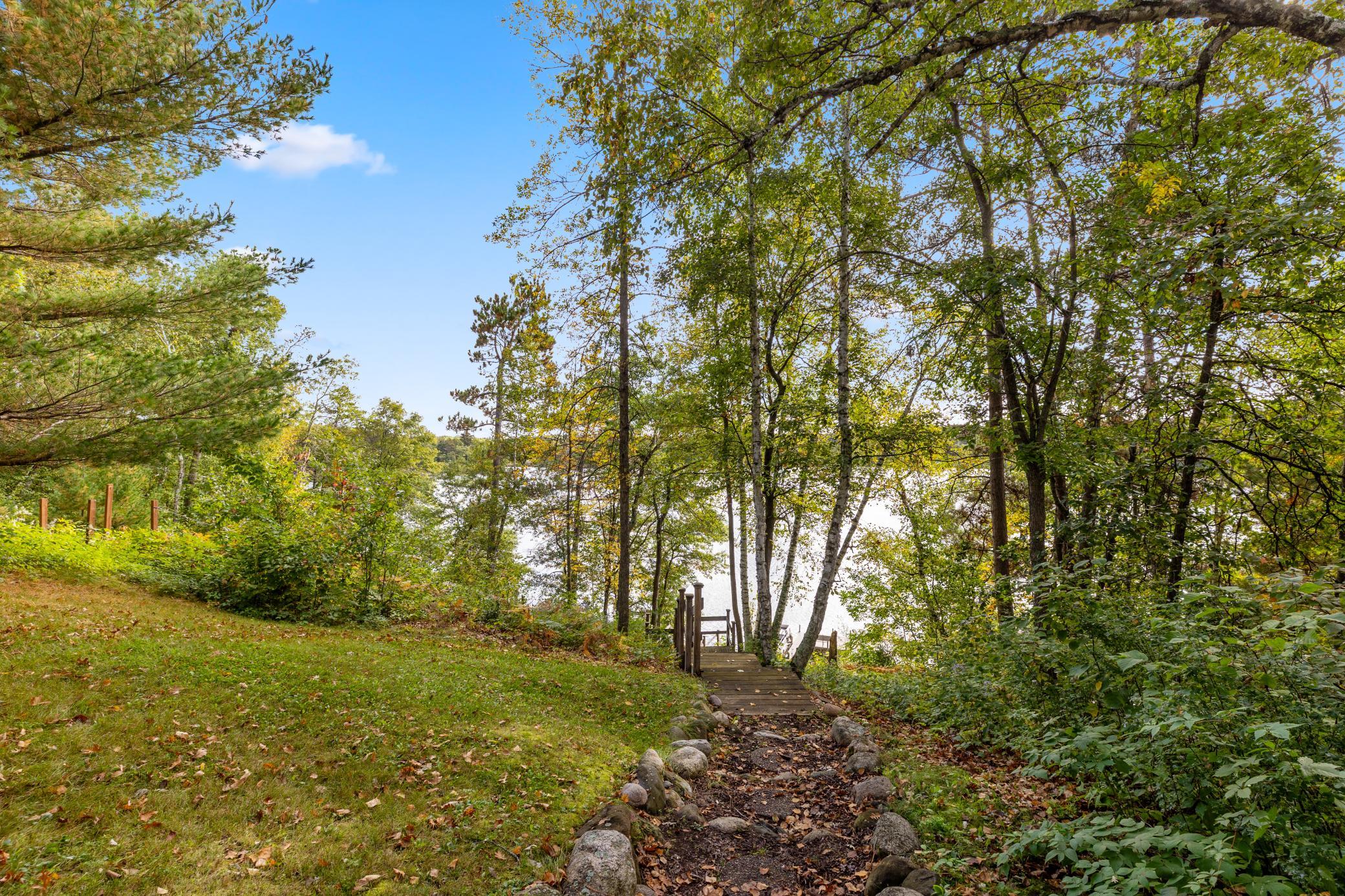 A natural path leads through the trees to a wooden staircase with easy access to the water