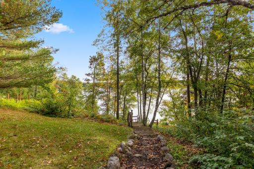 A natural path leads through the trees to a wooden staircase with easy access to the water