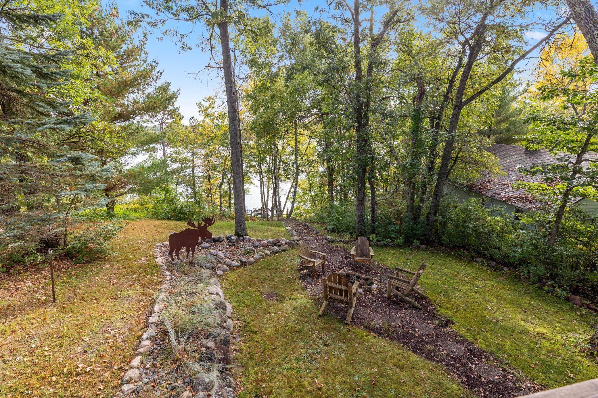 A tranquil, wooded setting surrounds the home, with a beautiful yard that winds down to the lake and creates the perfect private retreat