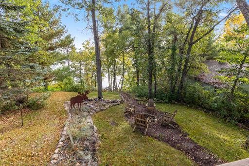 A tranquil, wooded setting surrounds the home, with a beautiful yard that winds down to the lake and creates the perfect private retreat