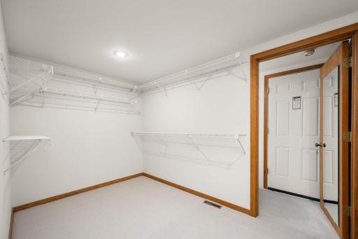 Primary Walk in closet. The door leads to walk in storage above the garage.