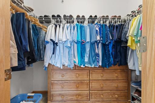 A spacious walk-in closet with built-in drawers keeps clothing and everyday essentials organized.