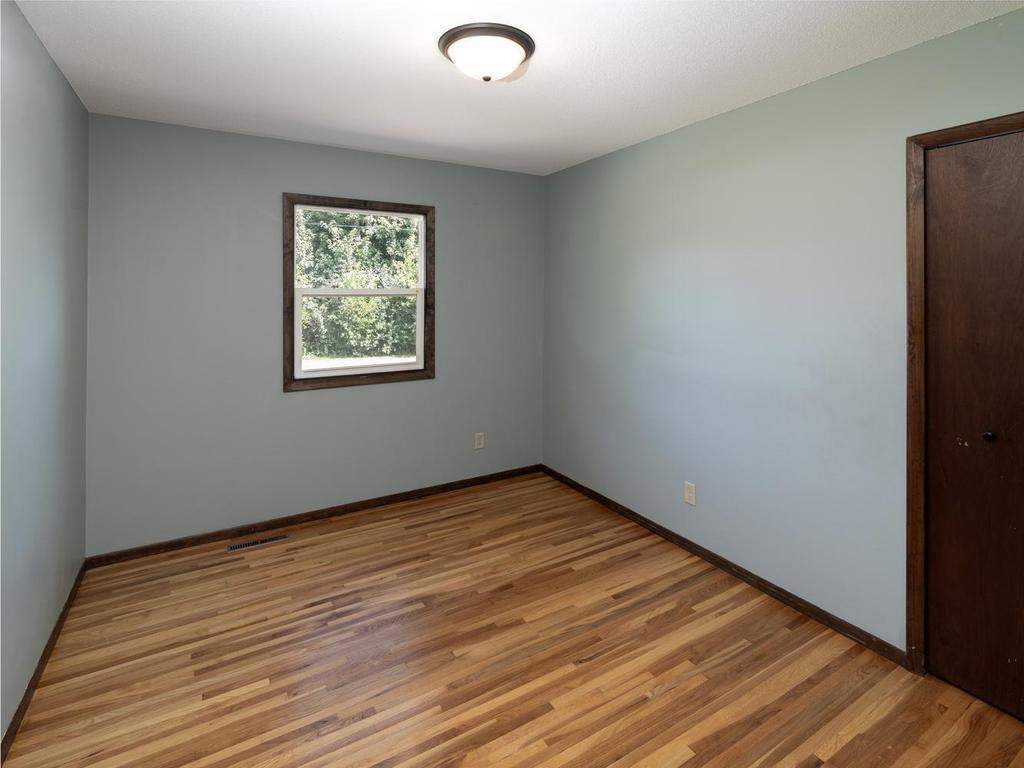 Third main-level bedroom with hardwood floors & leafy views