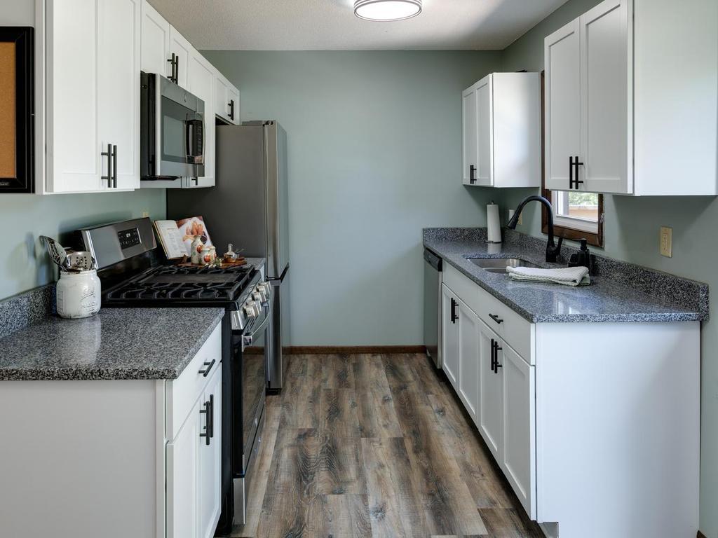 Updated kitchen with granite countertops, white shaker cabinets & gas range