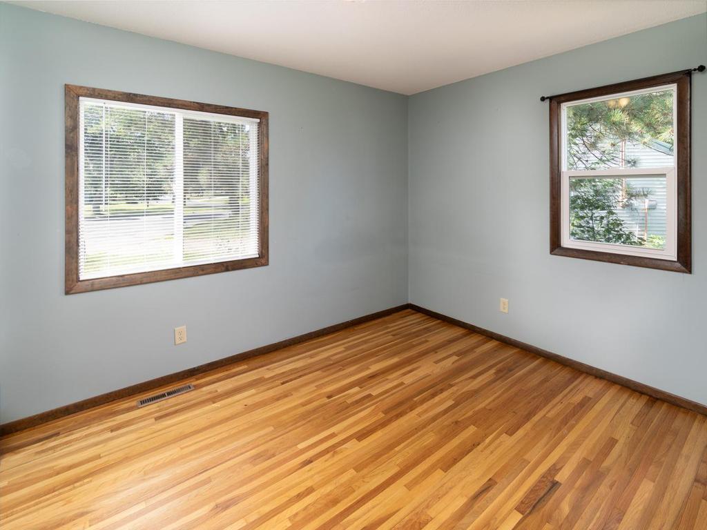 First of three main-level bedrooms with hardwood floors & windows on two walls