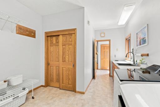 Large laundry room with abundant cabinets and folding counter.