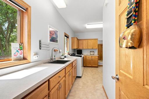 Oversized main-level laundry with utility sink and extensive cabinetry.