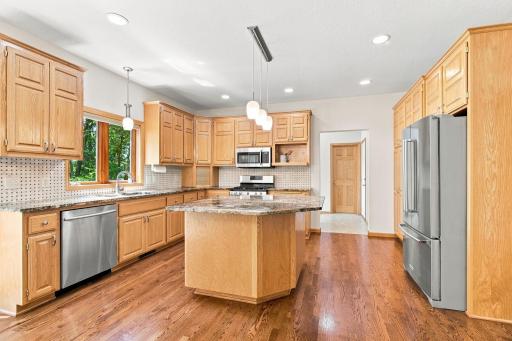 Natural hardwood floors and granite island create a timeless kitchen.