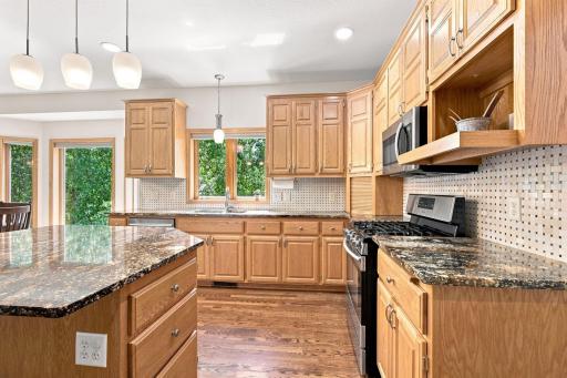 Abundant cabinetry and granite surfaces provide exceptional storage.