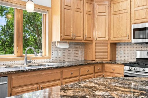 Abundant cabinetry and granite surfaces provide exceptional storage.