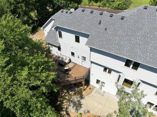 Large maintenance-friendly deck overlooks the private wooded backyard, creating an ideal space for outdoor dining, entertaining, or simply relaxing while enjoying peaceful nature views.