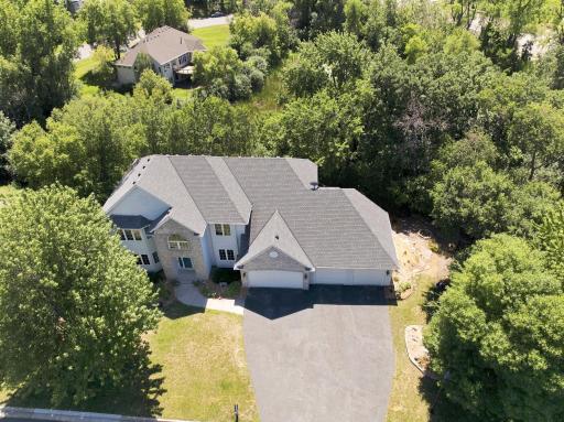 Aerial view highlights the home's impressive footprint, oversized 4-car garage, mature landscaping, and premium wooded homesite. Enjoy exceptional privacy while remaining minutes from shopping, restaurants, parks, and major commuting routes.