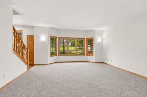 Versatile front living room with oversized windows offers the perfect space for entertaining, reading, or a piano room.