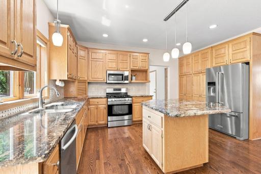 Natural hardwood floors and granite island create a timeless kitchen.