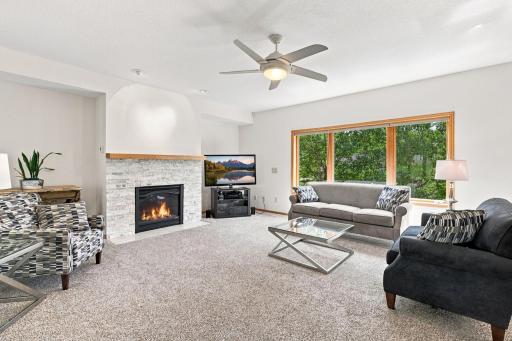 Beautiful gas fireplace anchors the family room while large windows showcase peaceful wooded views and abundant natural light.