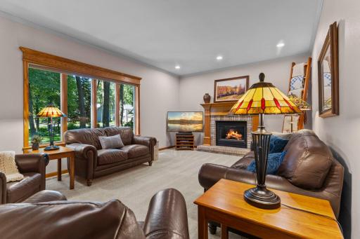 Living room anchored by beautiful backyard views and a brick surrounded fireplace.