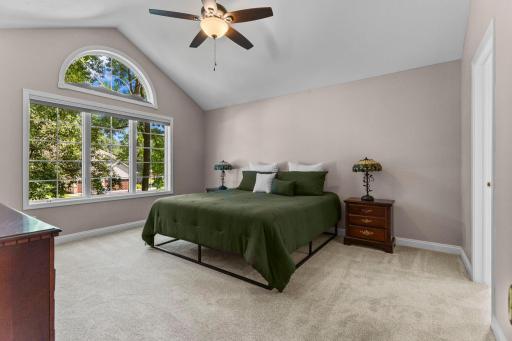 Primary suite with vaulted ceiling and large picture window offering plenty of natural light.