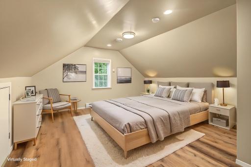 The upper level was recently refinished! This room features new LVP flooring, fresh paint, recessed lighting, a soothing paint scheme, a full sized closet and unusually high ceilings for a 1.5 story home! Photo is virtually staged to show potential.