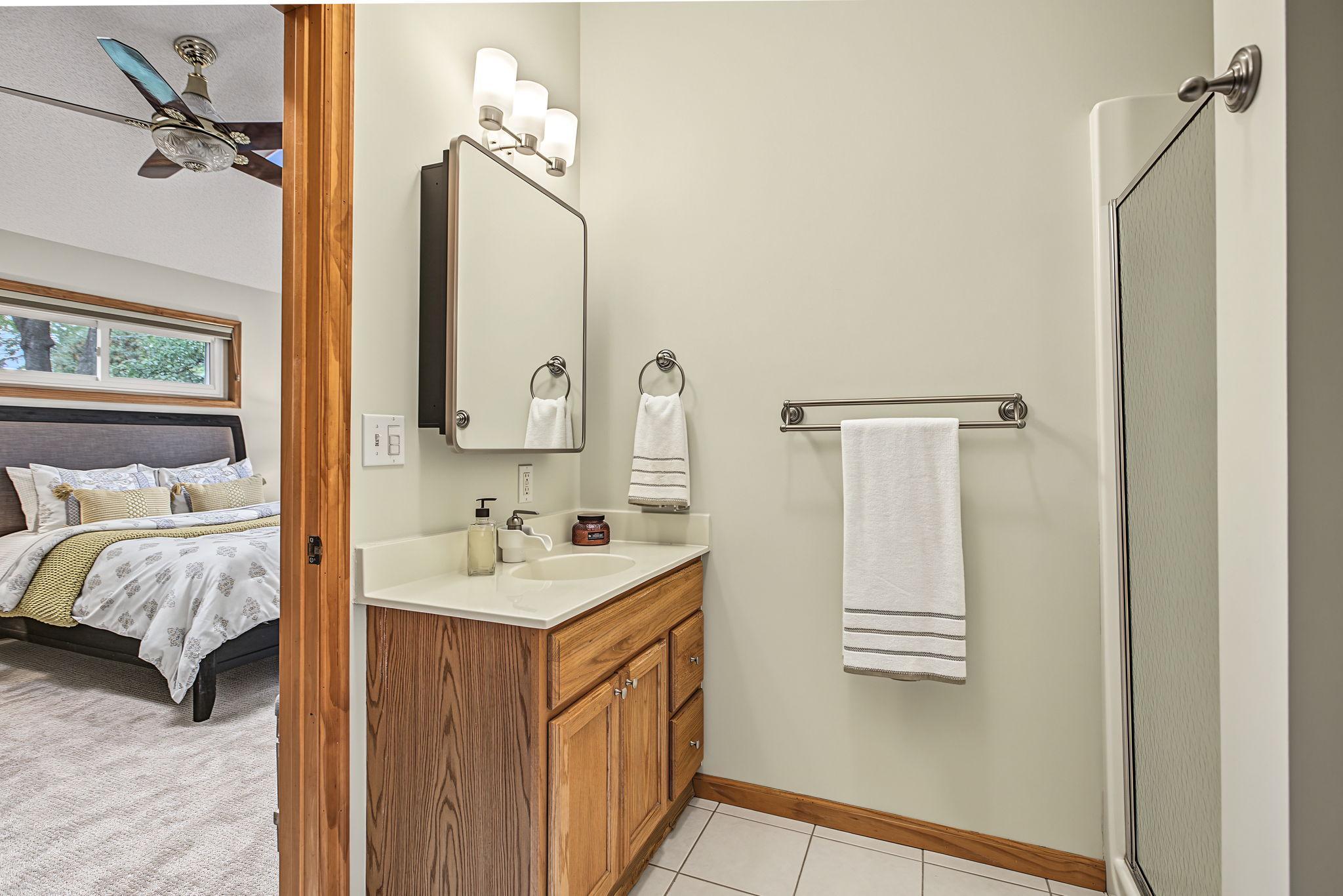 The bathroom features updated fixtures, a modern medicine cabinet, and new lighting.