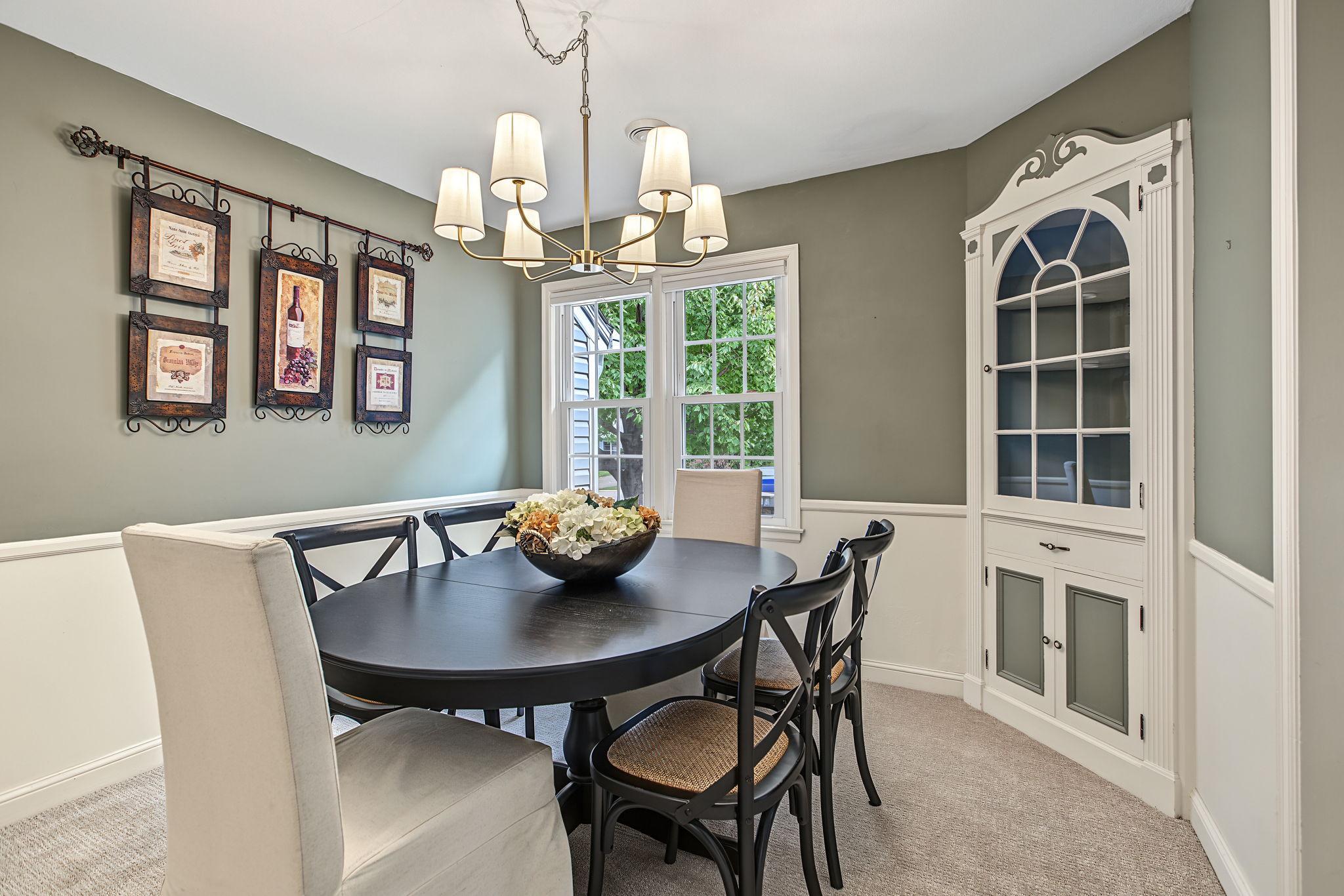The dining room features an original built-in buffet, a modern yet classic chandelier and lovely windows.