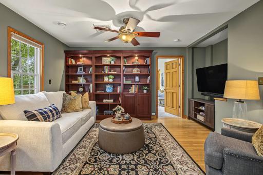 The den is a cozy spot to curl up at the end of a long day. Enjoy original hardwood floors, built in bookcases with ambient light, and when it is time to retire for the evening you are just right new door to the main-floor primary suite.