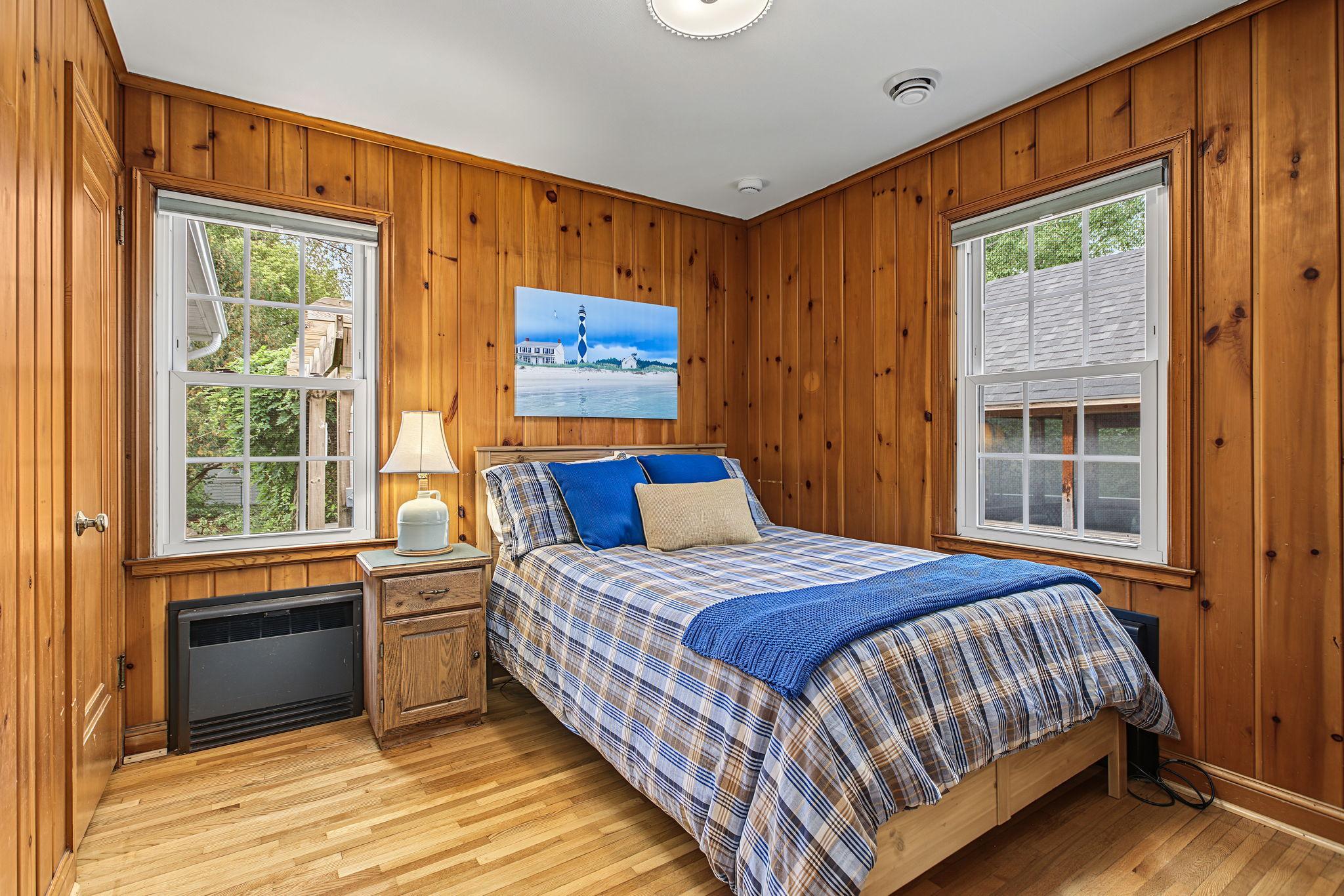 The 2nd bedroom on the main floor features beautiful hardwood floors, updated lighting and wide plank knotty pine tongue and groove paneling. The 2 windows provide abundant natural light.