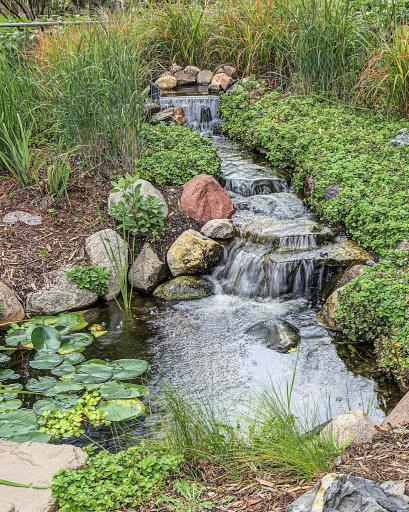 The tranquility of the yard is amped up by this beautiful water garden with rock falls. You can feel like you are on vacation in your own backyard.