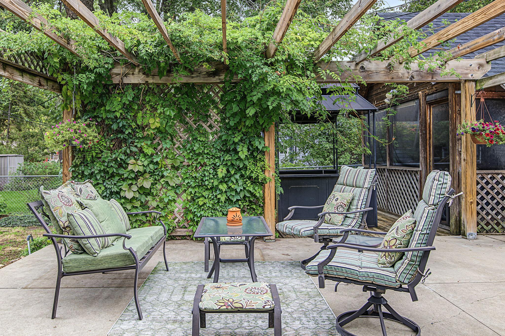 The yard has a spacious patio with a pergola and trellis covered in Wisteria and Trumpet Flowers. The vines are always pretty, but they are especially lovely when in full bloom.