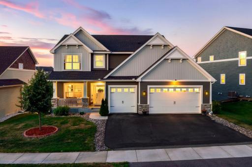 Photo for 19387 Primrose Lane N, Corcoran, MN 55340 - listing #7107812 Beautiful two-story home illuminated at sunset, featuring stone accents, a inviting front porch, and a spacious 3-car garage