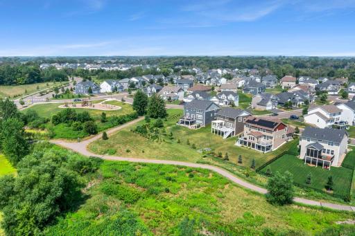 Broad drone view showing the home nestled within a peaceful, nature-filled community with expansive greenspace views.