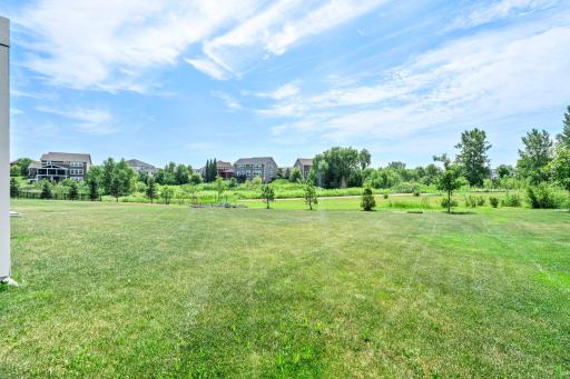 Broad view of the green space behind the property, offering a serene, open feel and picturesque views.