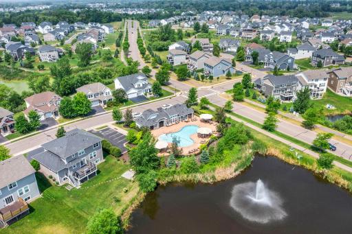 High-angle perspective showing the poolside amenity center situated directly next to the scenic community pond.