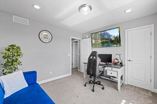 Alternate view of the spacious secondary bedroom showing built-in lighting and ample room for furniture or study setups.