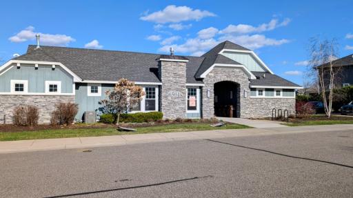 Wide view of the neighborhood clubhouse showing its attractive curb appeal, paved sidewalk access, and convenient location.