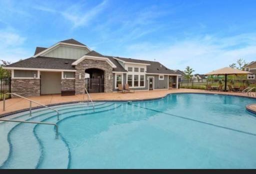 Sparkling outdoor pool area complete with zero-entry steps, a spacious sunbathing deck, and convenient access to the clubhouse.