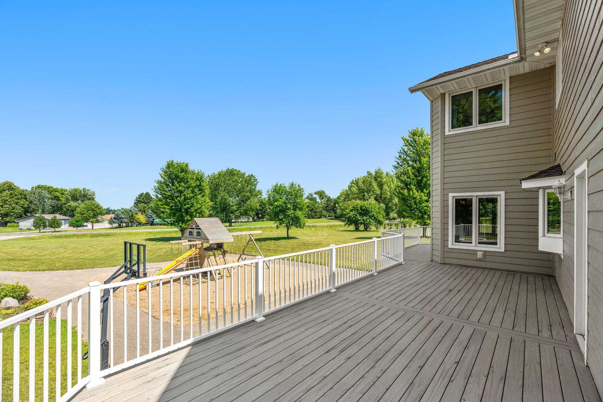Walkout to Deck overlooking stunning backyard w/ outdoor Basketball Court & Play area