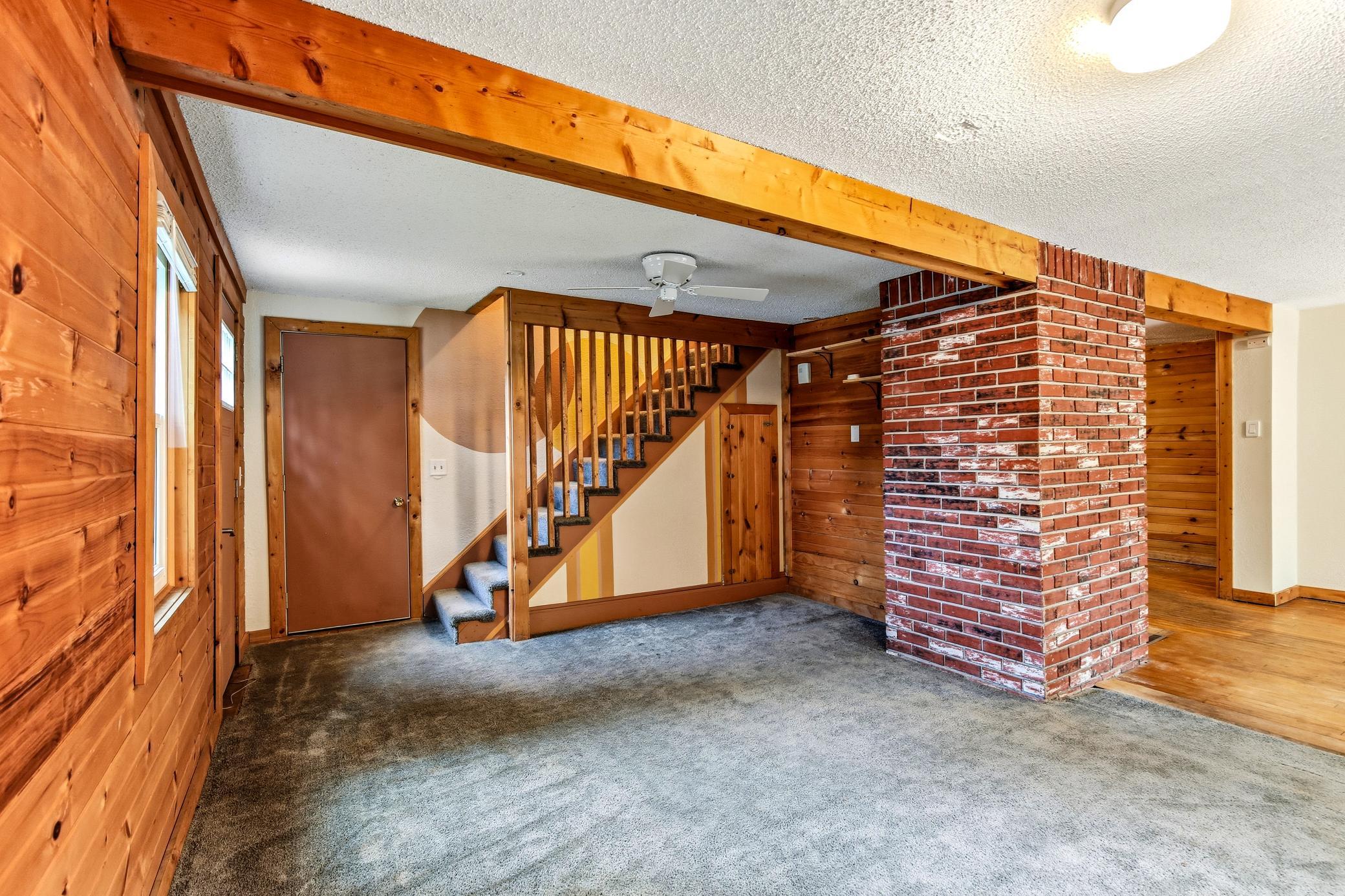 Brick wall, wood beam and unique staircase add more character