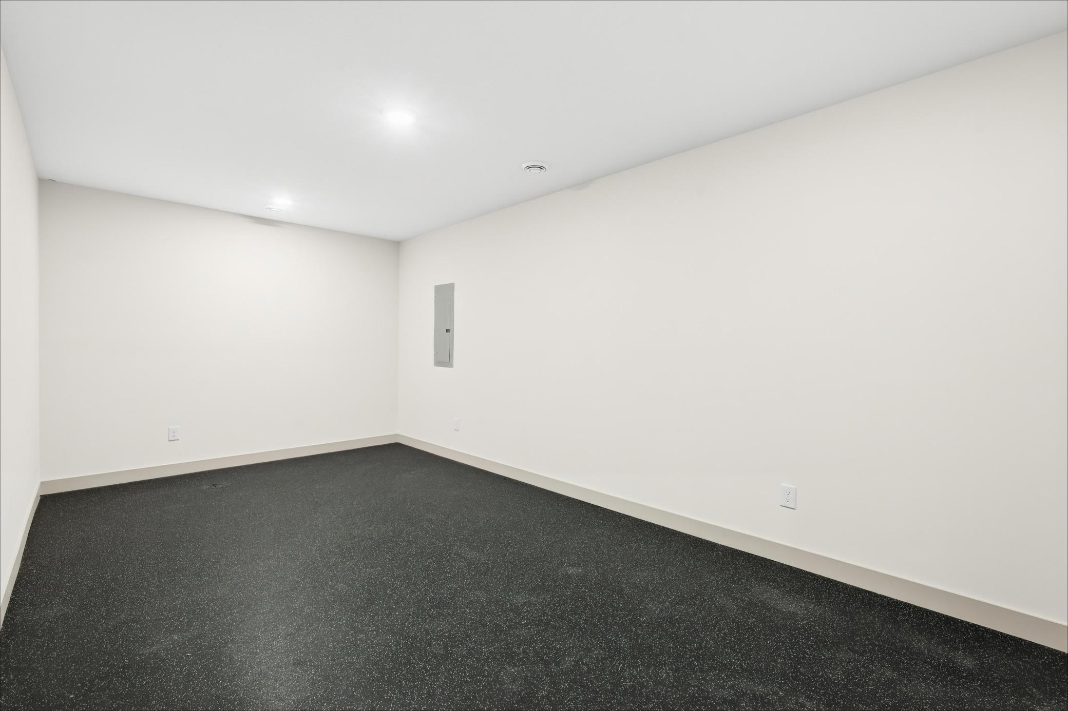 Home Gym / Flex Room
Dedicated fitness flex space outfitted with commercial-grade rubberized athletic flooring and recessed lighting—ready for a home workout studio, yoga room, or specialized hobby space.