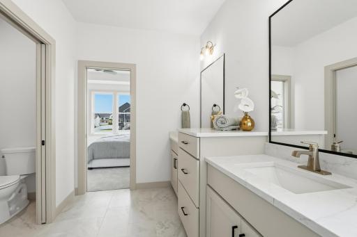 Primary En-Suite Layout
Functional primary bathroom layout showcasing the double vanity design, marble-look tiled flooring, private water closet room, and direct, convenient access into the primary bedroom suite.