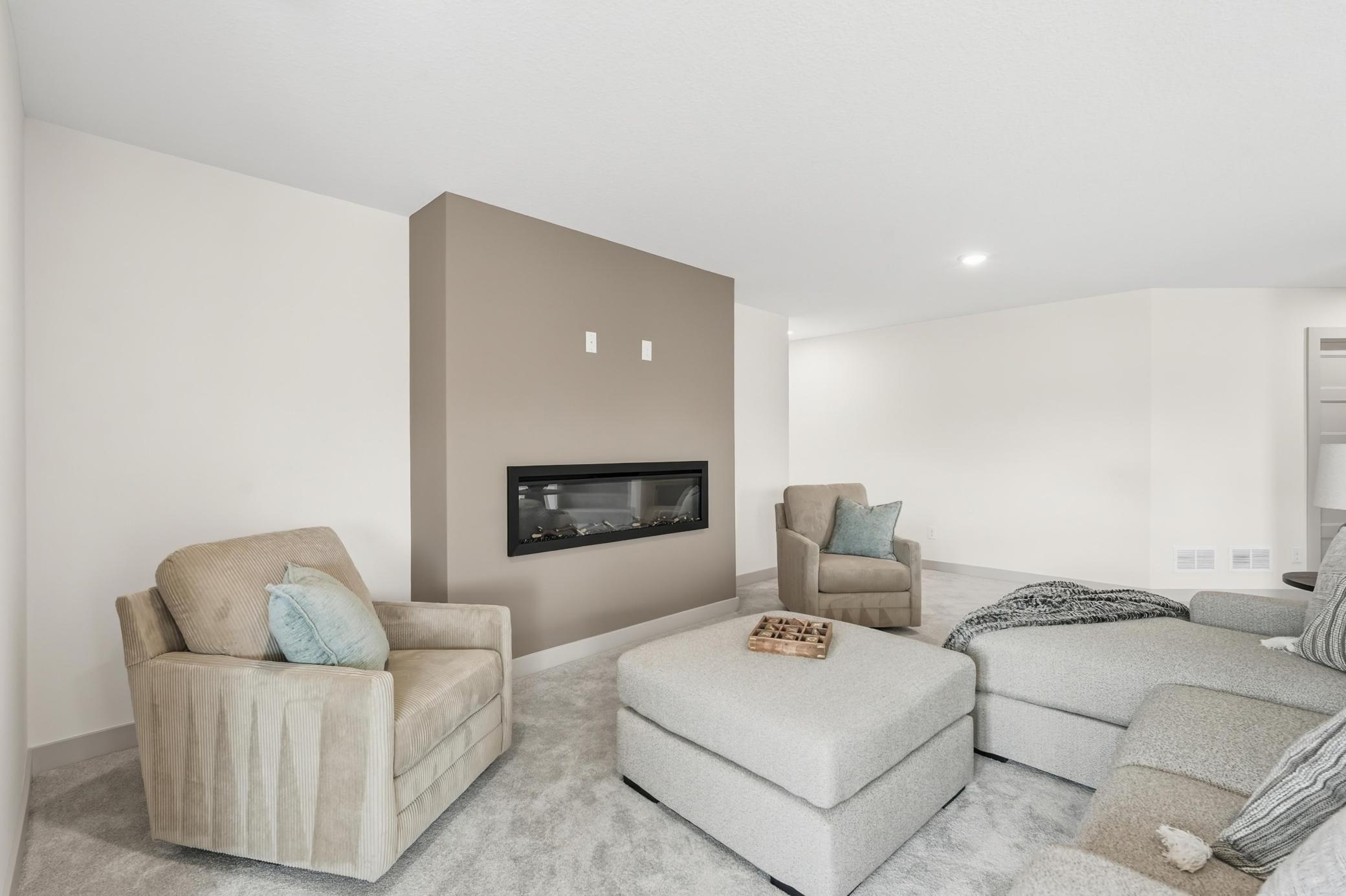 Lower-Level Fireplace Lounge
Welcoming lower-level lounge focused around a flush-mount linear electric fireplace with an oversized accent wall prewired for seamless wall-mounted television placement ready for family gatherings or football on weekends