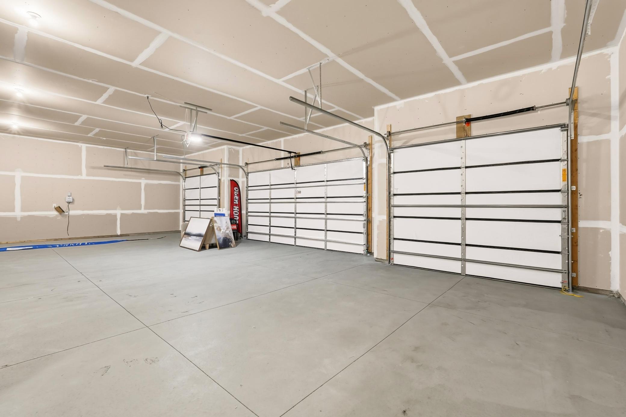 Oversized Multi-Car Garage
Enormous multi-car garage featuring high ceilings, clean concrete flooring, multiple overhead doors, and massive storage or workshop potential.