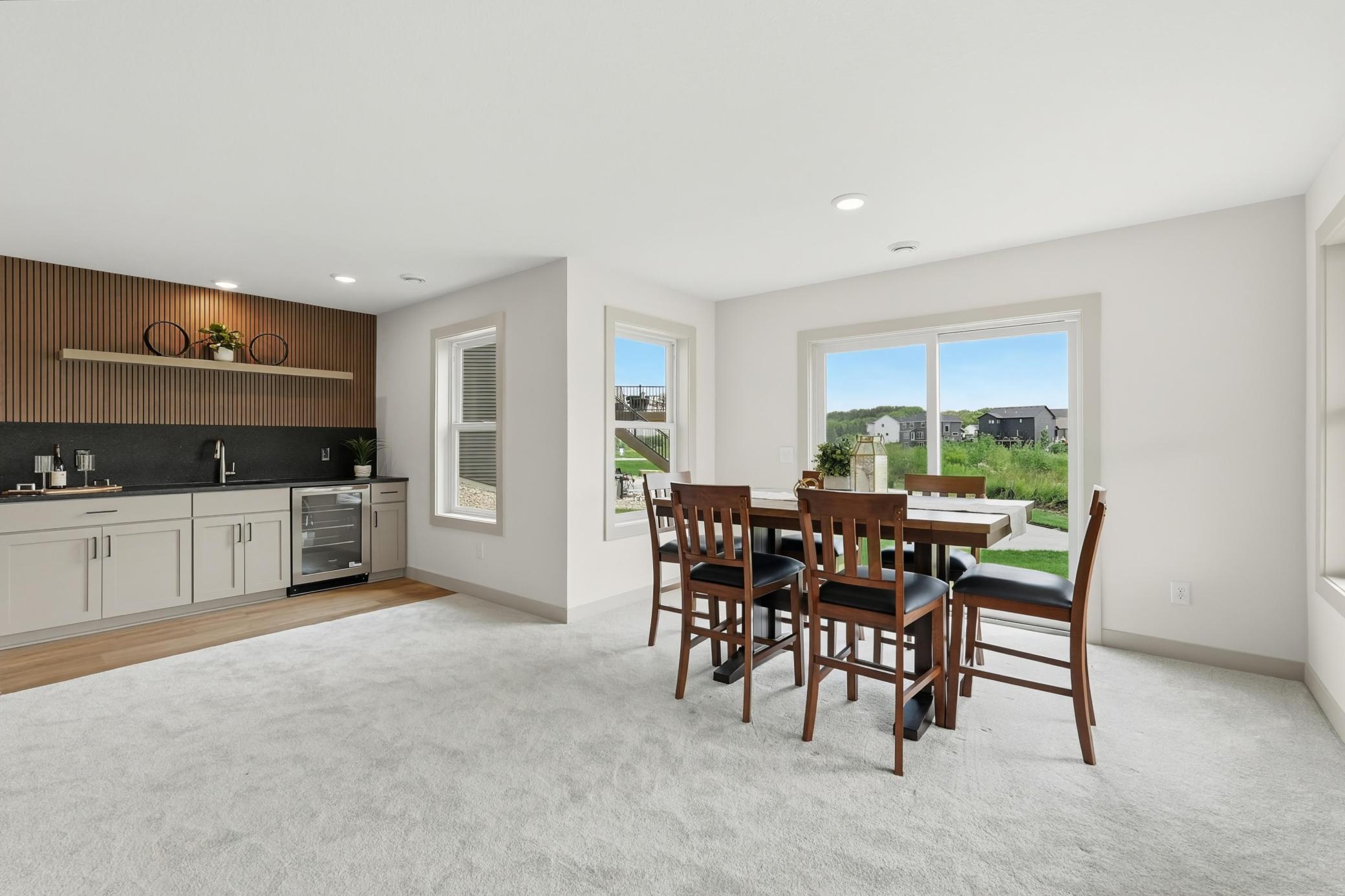Lower level dining_Area or game space
Open-concept lower-level dining space featuring effortless flow to the custom wet bar, plush carpeting, and sliding glass doors that open directly to the outdoor patio and lawn.