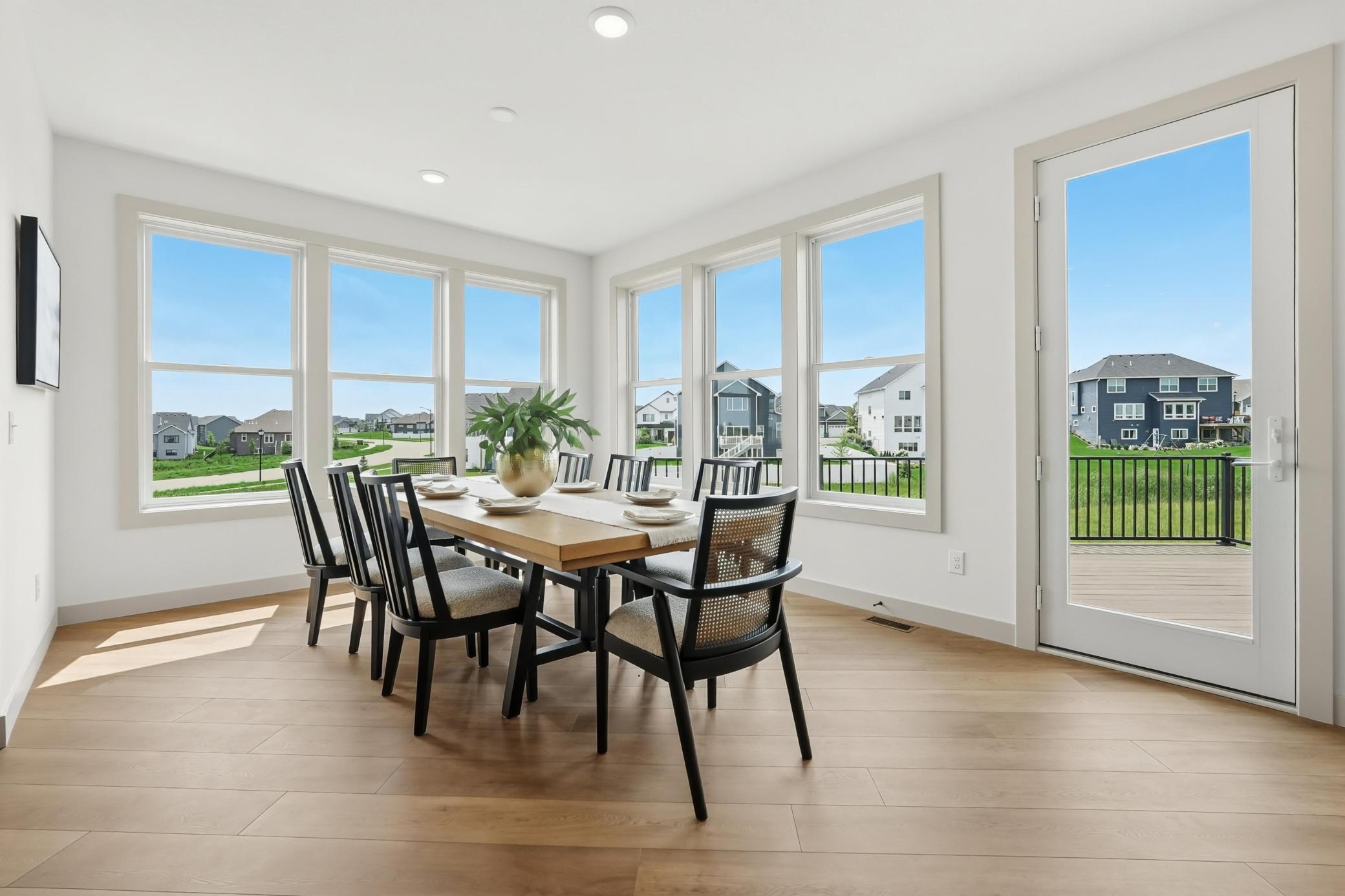 Dining Room & Deck Access
Sun-drenched dining space wrapped in large windows on two walls, featuring warm plank flooring and direct glass-door walkout access to the rear outdoor deck perfect for grilling or entertaining.